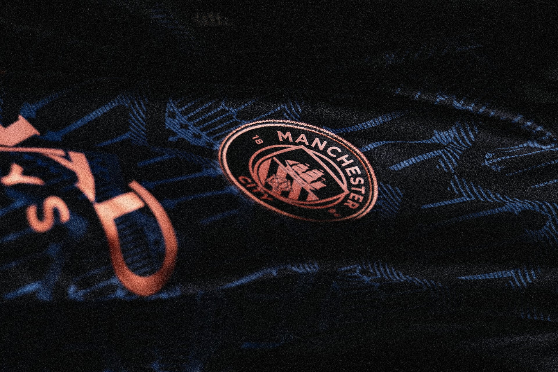 Close-up of a Manchester City logo on a dark background